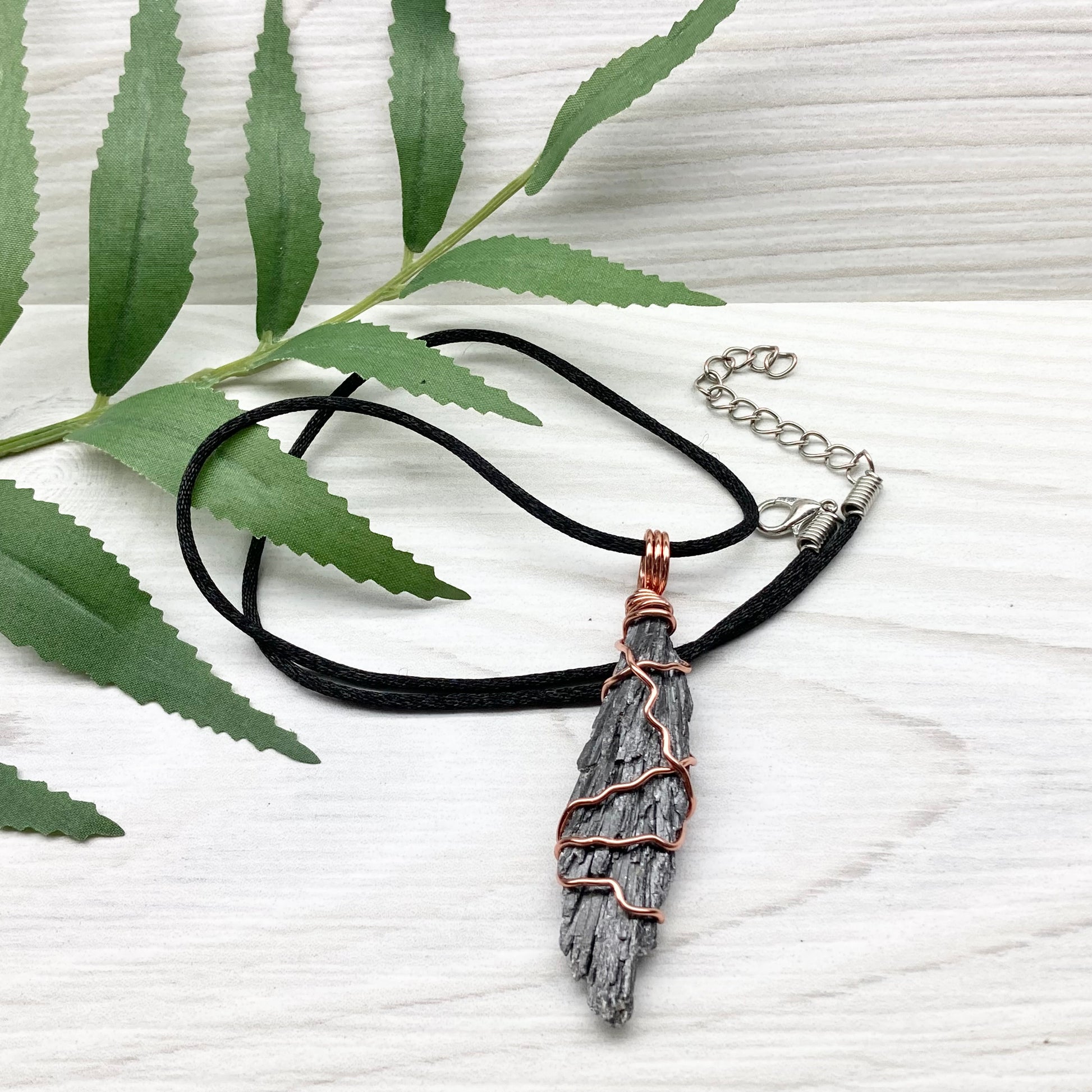 Black Kyanite necklace. Real raw Black Kyanite wrapped with tarnish resistant copper wire. Hangs on a black chain. Wire wrapped black crystal pendant. Spiritual gift.