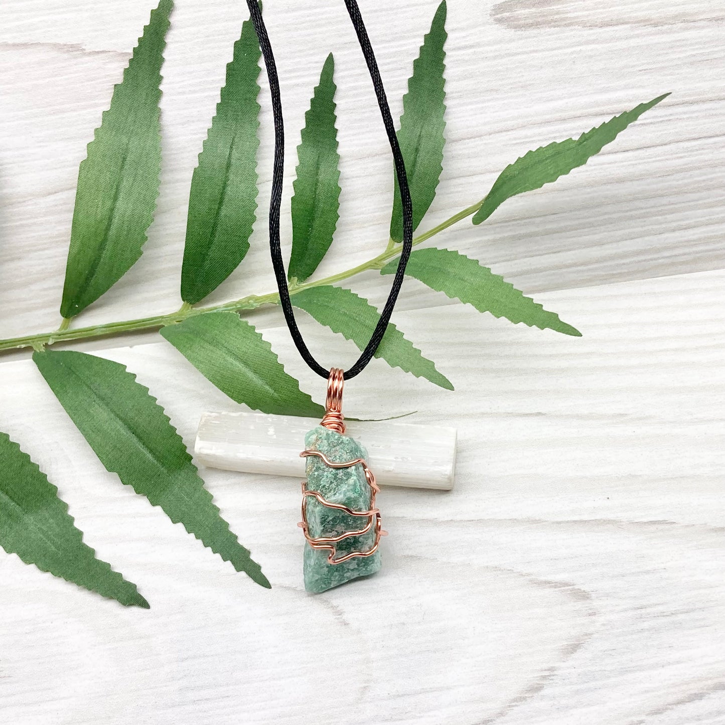 Green Aventurine Necklace. Raw Green Aventurine crystal wrapped with tarnish resistant copper. Comes on a black chain.