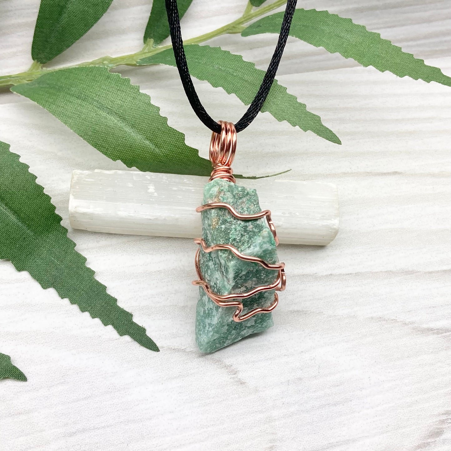 Green Aventurine Necklace. Raw Green Aventurine crystal wrapped with tarnish resistant copper. Comes on a black chain.