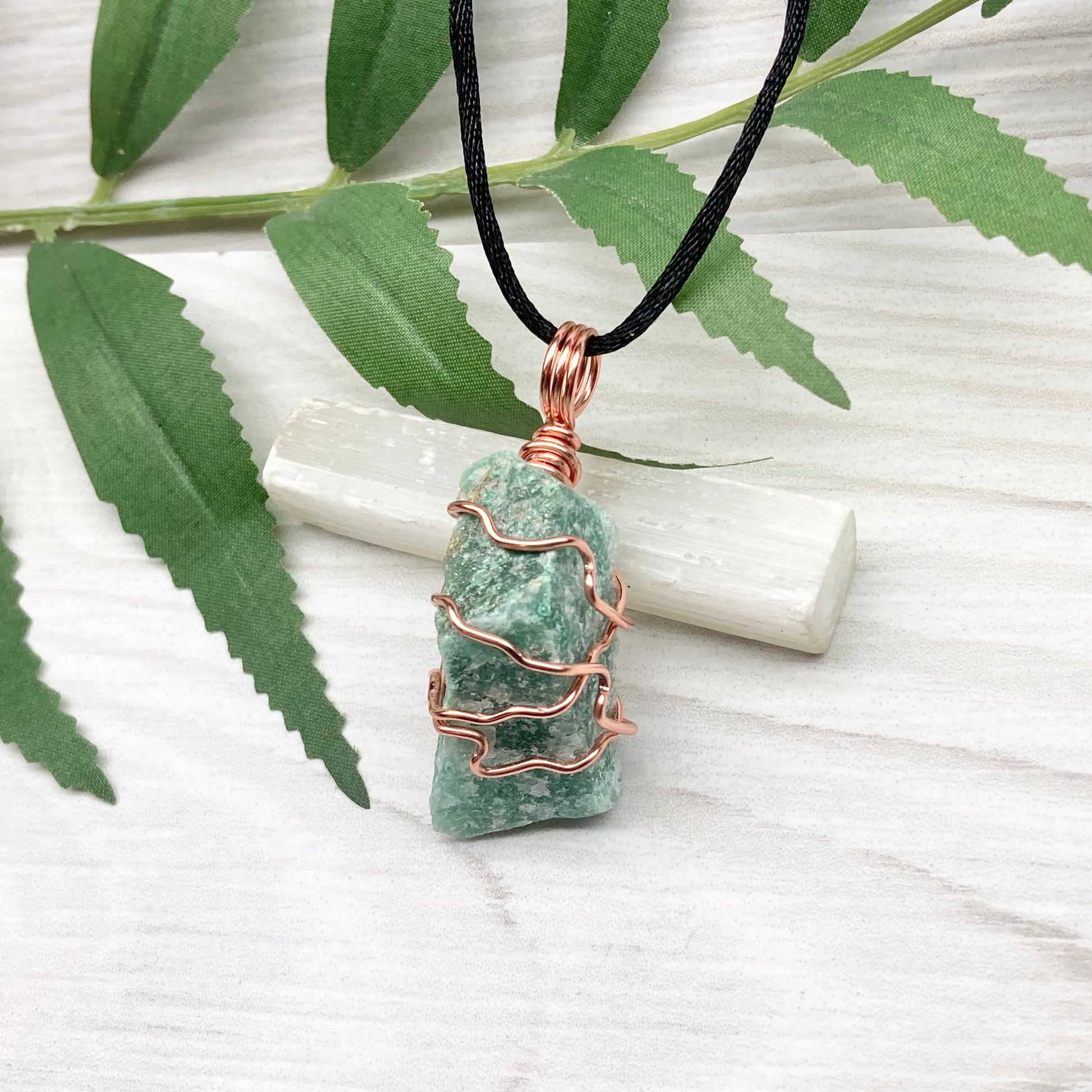 Green Aventurine Necklace. Raw Green Aventurine crystal wrapped with tarnish resistant copper. Comes on a black chain.