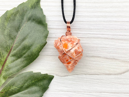 Orange Calcite Necklace. Raw Orange Calcite Crystal Wrapped With Copper Wire That Is Tarnish Resistant. Comes On A Black Necklace. Gemini Zodiac Stone Pendant. Handmade In Tennessee. Pagan Spiritual Jewelry.