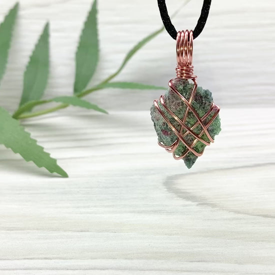 Raw Ruby Zoisite Necklace. This Ruby Zoisite Crystal Is Hand Wrapped With Pure Copper Wire For A Pendant. This Stone is Blue, Red And Green Colored. Comes On A Black Chain. Spiritual New Age Style Jewelry. Video Shows Pendant Spinning around.