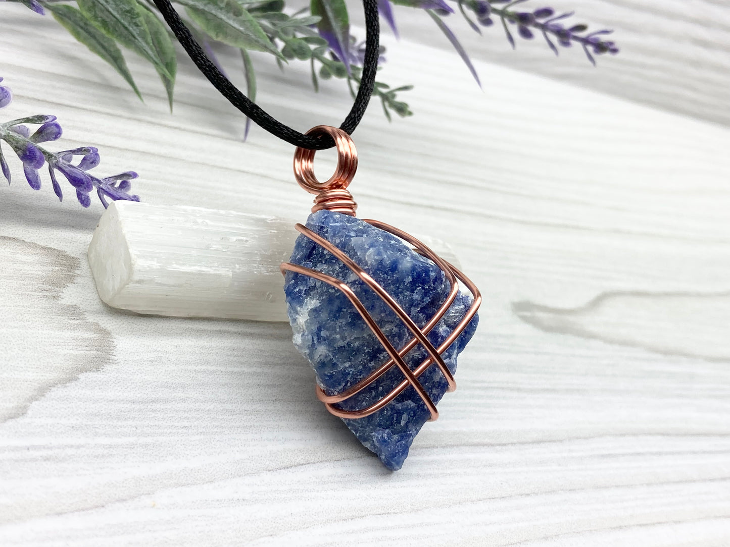 Raw Sodalite Necklace. Right Side View. Real Sodalite Crystal Hand Wrapped With Pure Copper Wire. Gemstone Is Blue With White In It. Comes On A Black Chain. Sagittarius Zodiac Stone Unisex Jewelry.