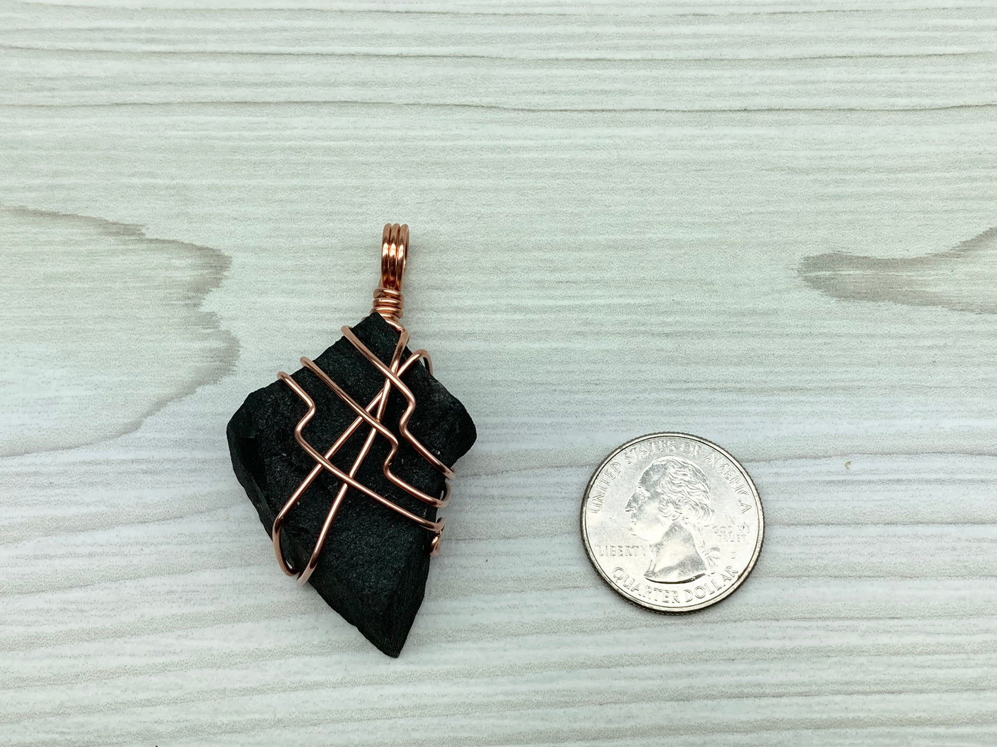 Black Agate stone wrapped with copper wire.  Pendant is double the size of a quarter,