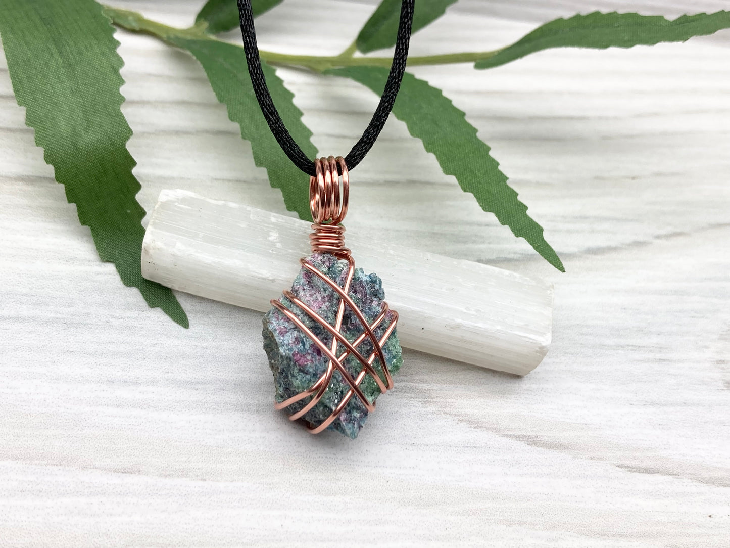 Raw Ruby Zoisite Necklace. This Ruby Zoisite Crystal Is Hand Wrapped With Pure Copper Wire For A Pendant. This Stone is Blue, Red And Green Colored. Comes On A Black Chain. Spiritual New Age Style Jewelry.