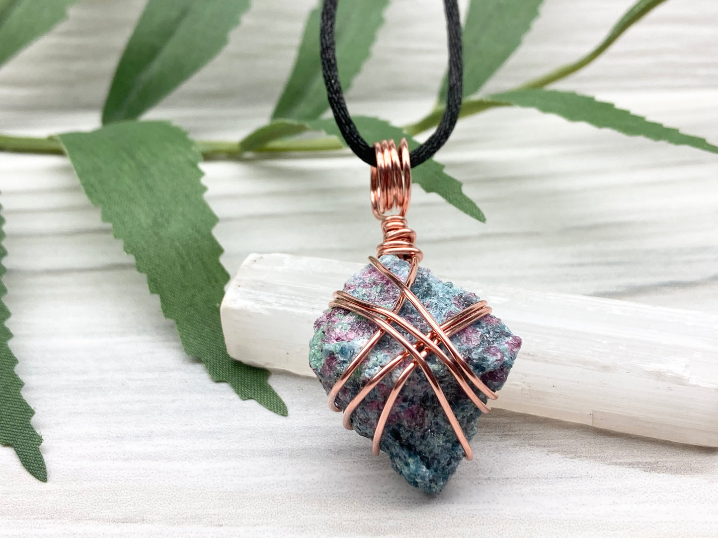 Rough Raw Ruby Zoisite Necklace. This Ruby Zoisite Crystal Is Hand Wrapped With Pure Copper Wire. This Stone is Blue and Red Colored. Gemstone Comes On A Black Chain. Spiritual New Age Style Unisex Jewelry.