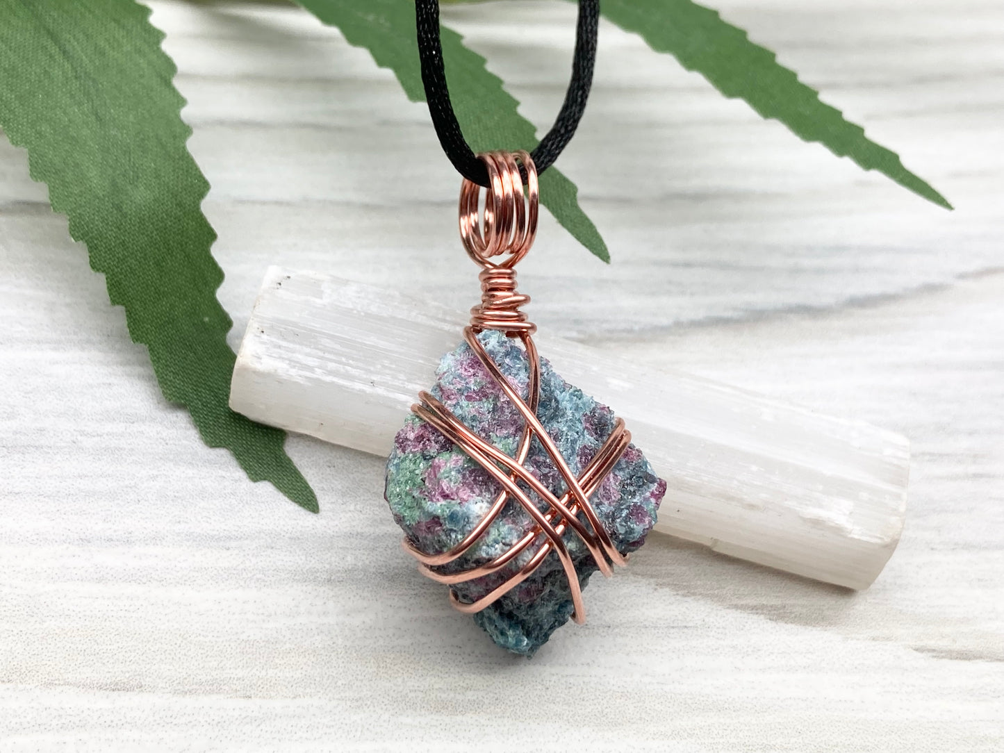 Rough Raw Ruby Zoisite Necklace. This Ruby Zoisite Crystal Is Hand Wrapped With Pure Copper Wire. This Stone is Blue and Red Colored. Gemstone Comes On A Black Chain. Spiritual New Age Style Unisex Jewelry.