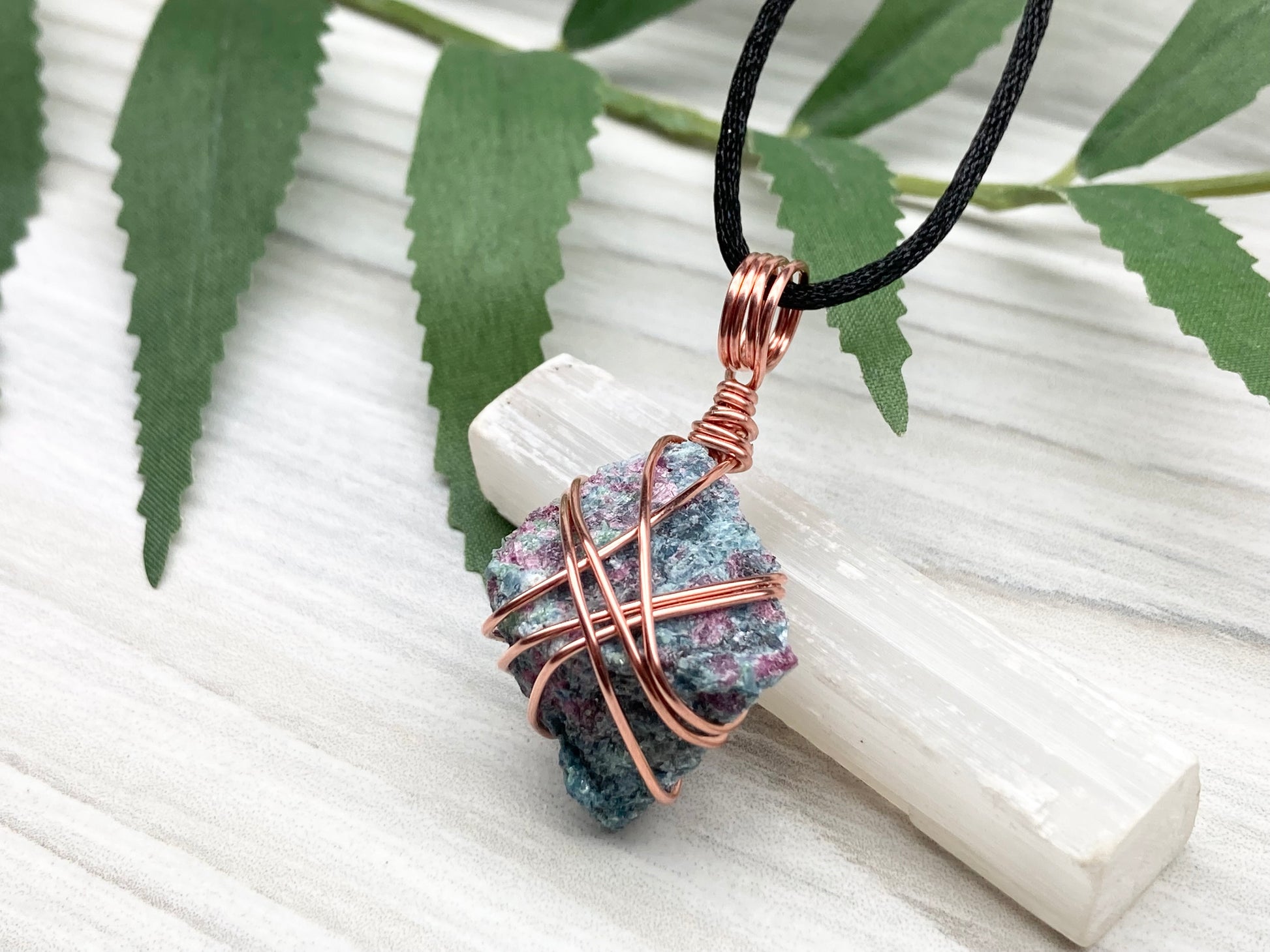 Rough Raw Ruby Zoisite Necklace. This Ruby Zoisite Crystal Is Hand Wrapped With Pure Copper Wire. This Stone is Blue and Red Colored. Gemstone Comes On A Black Chain. Spiritual New Age Style Unisex Jewelry.